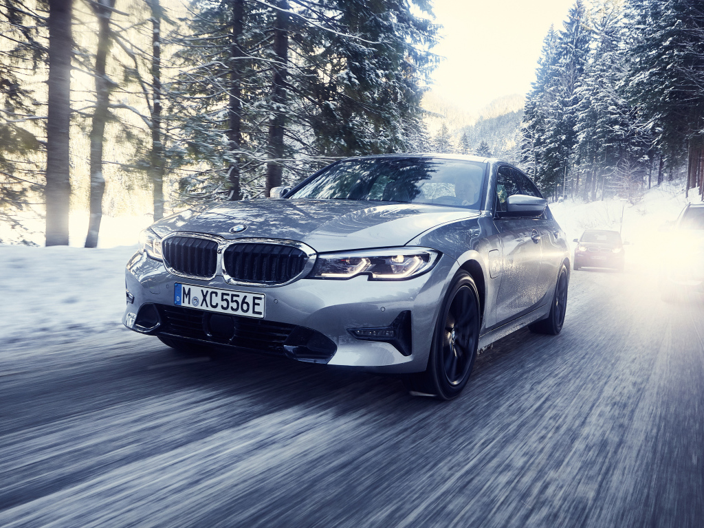 Серый автомобиль BMW 330e 2019 года на скользкой трассе
