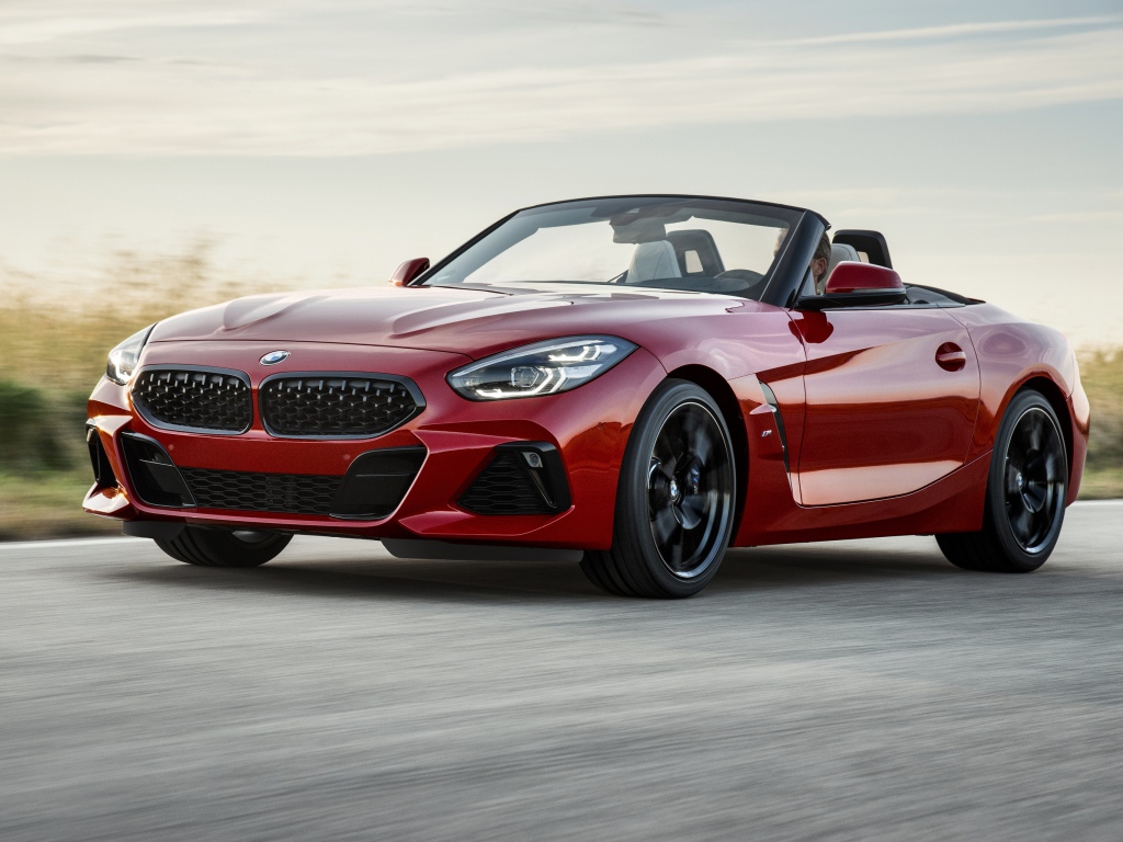 Красный автомобиль кабриолет BMW Z4 на дороге