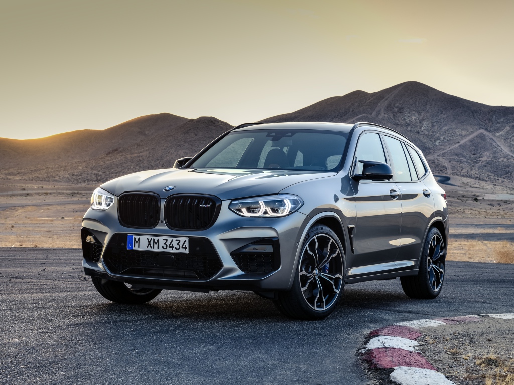 Серебристый автомобиль BMW X3  на асфальте