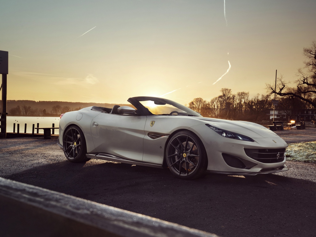 Серебристый кабриолет Ferrari Portofino 2019 года на фоне заката