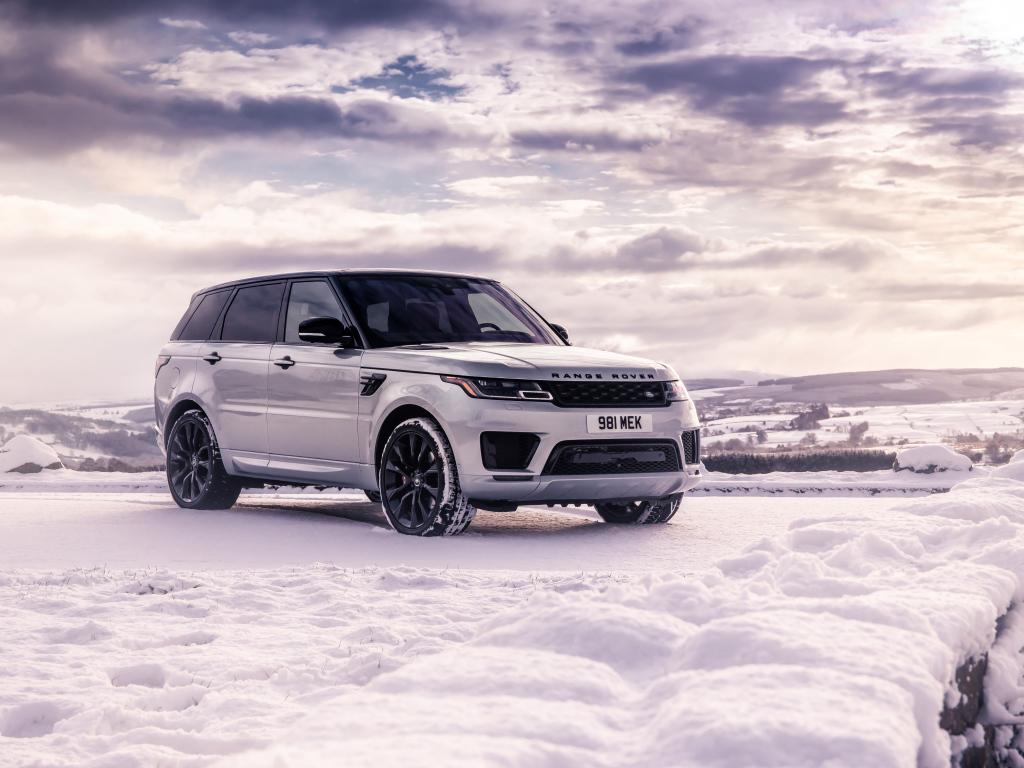 Серебристый внедорожник Range Rover Sport стоит на снегу
