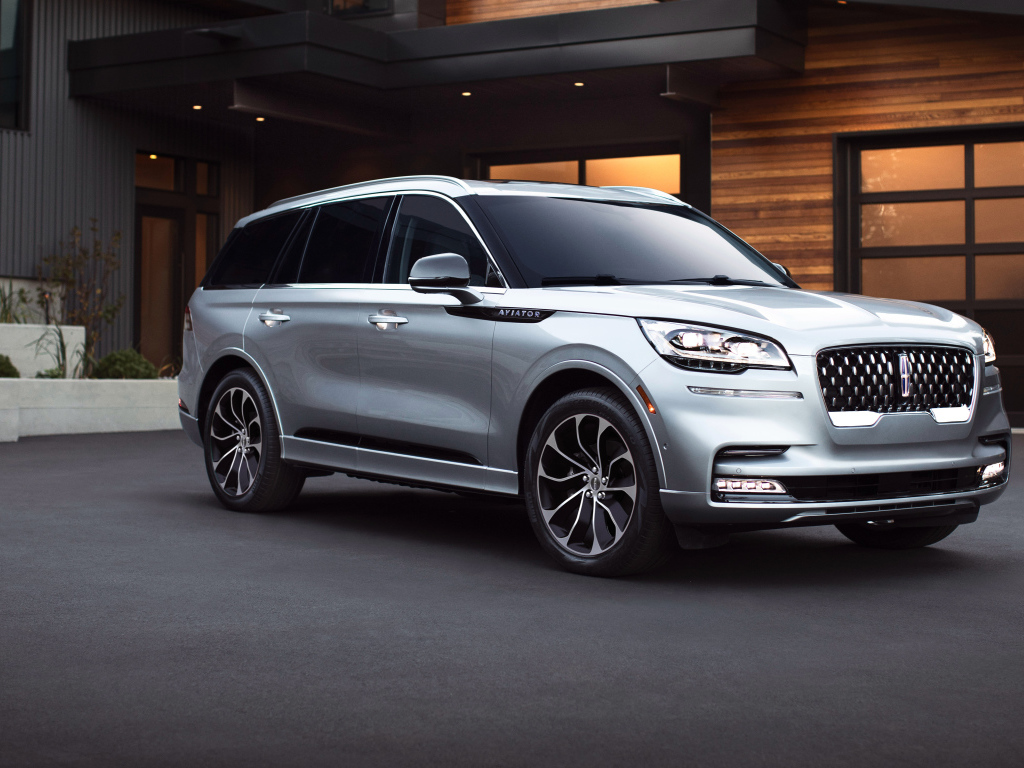 Серебристый внедорожник Lincoln Aviator Grand Touring, 2020 года на фоне дома