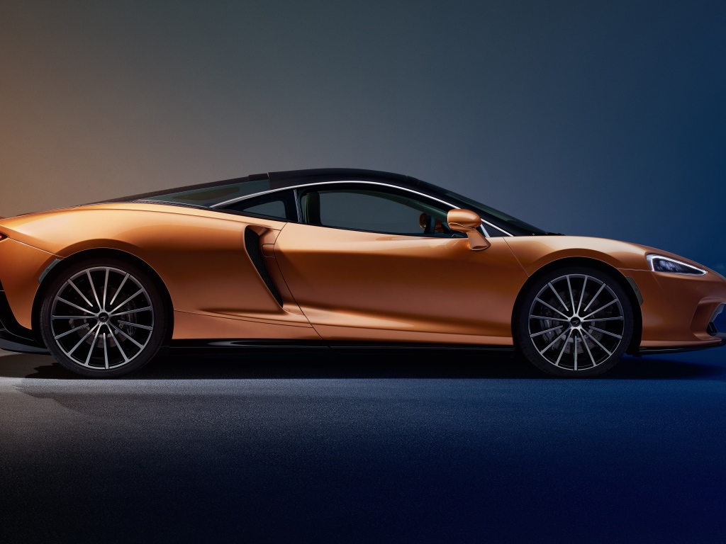 Оранжевый автомобиль McLaren GT Superlight 2019 года на синем фоне