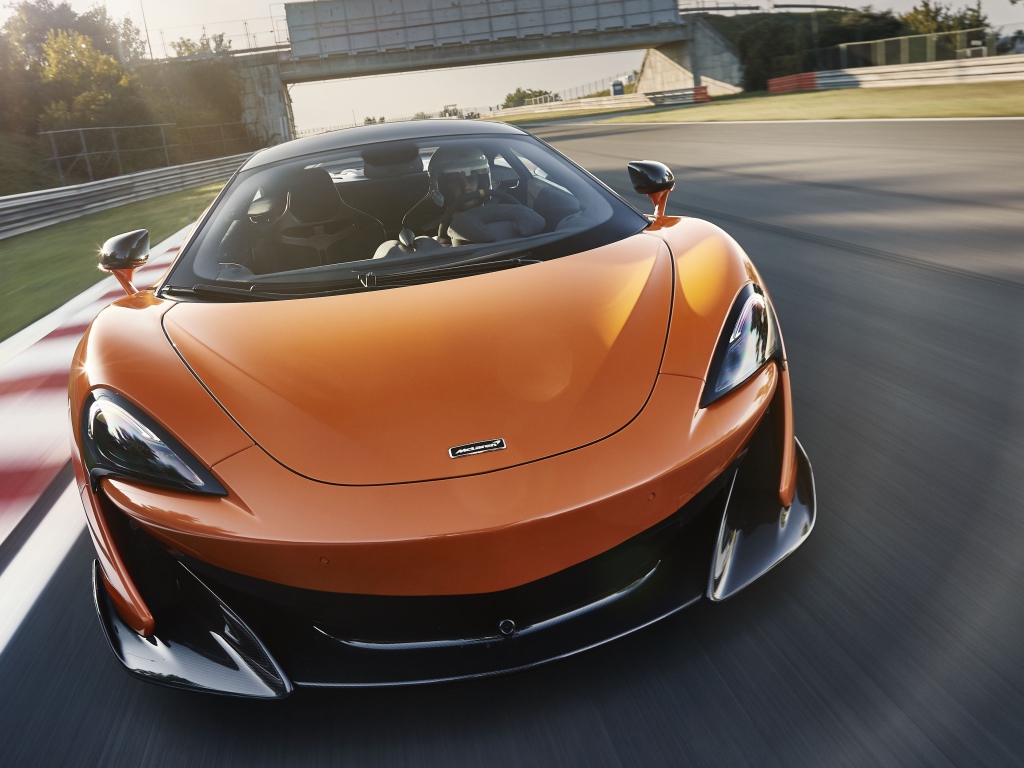 Спортивный оранжевый автомобиль McLaren 600LT 2019 года на трассе