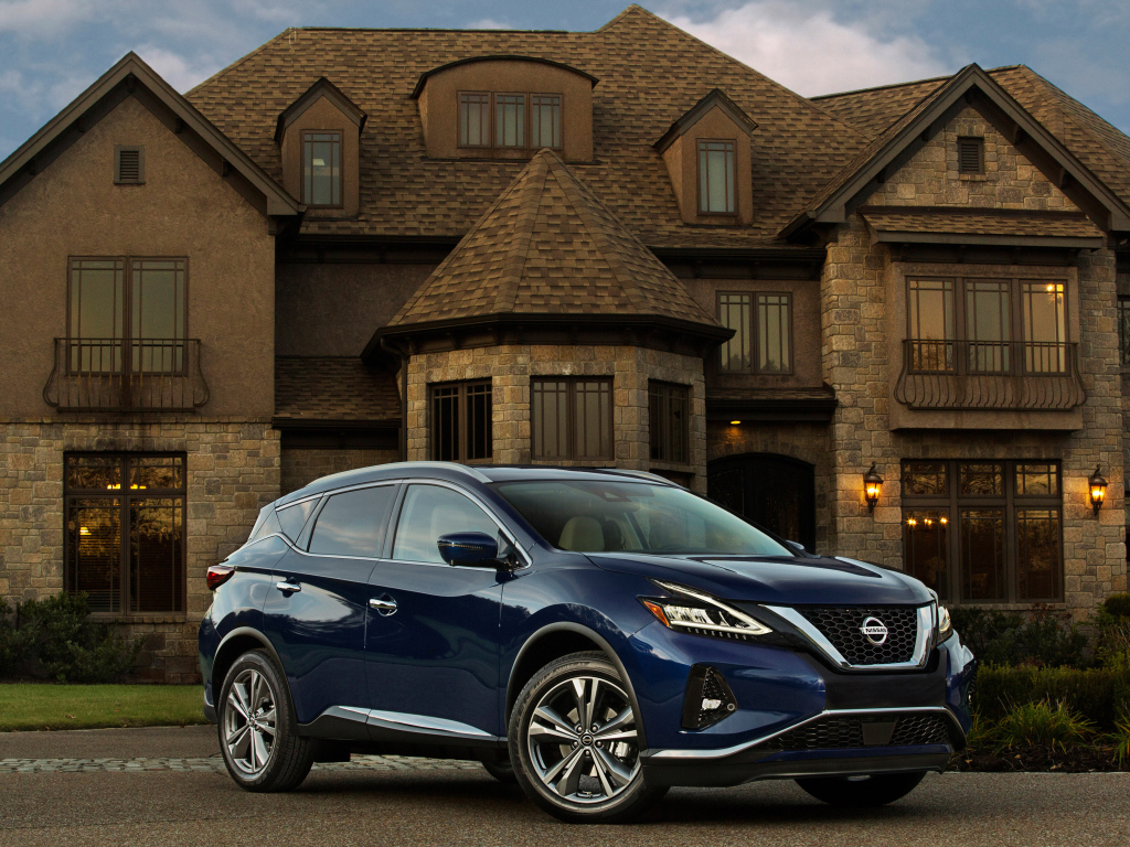 Синий автомобиль Nissan Murano на фоне особняка