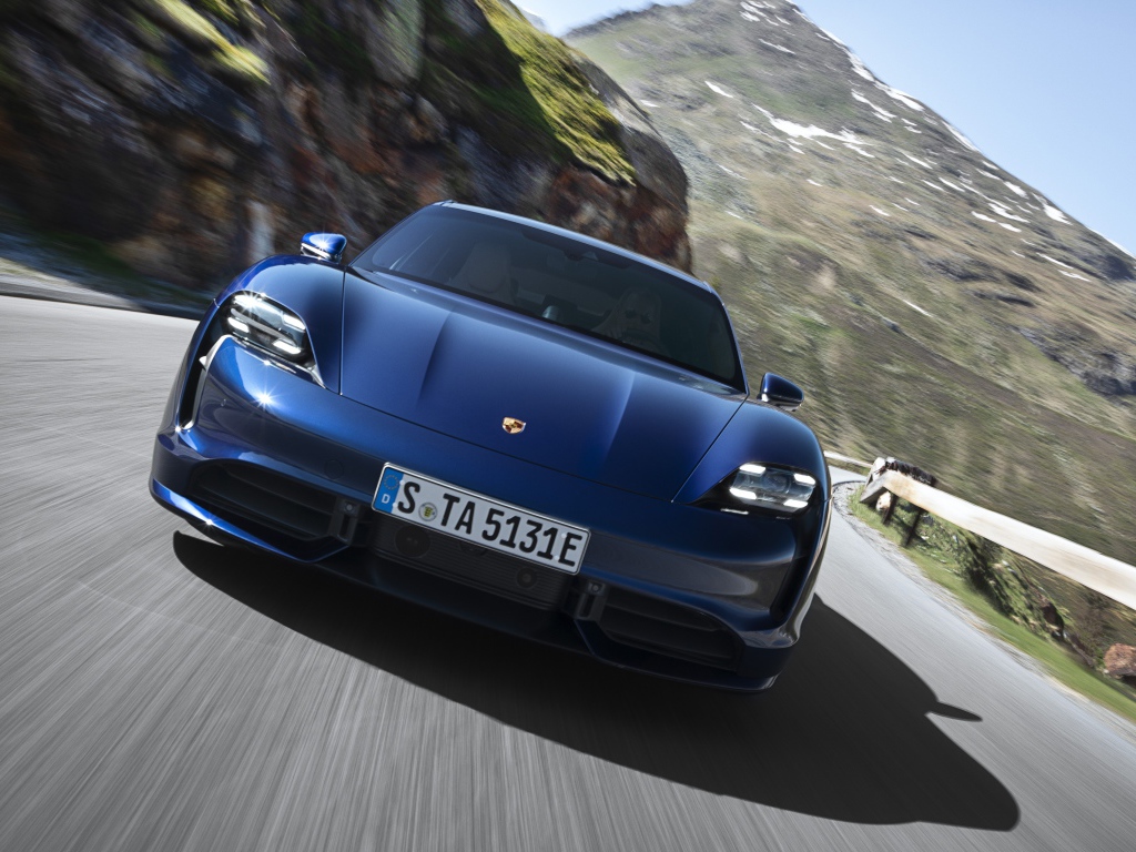 Синий автомобиль Porsche Taycan Turbo 2019 года на фоне гор