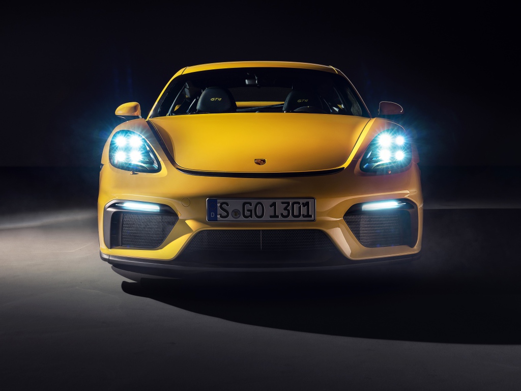 Автомобиль Porsche 718 Cayman GT4,  2019 года с включенными фарами 