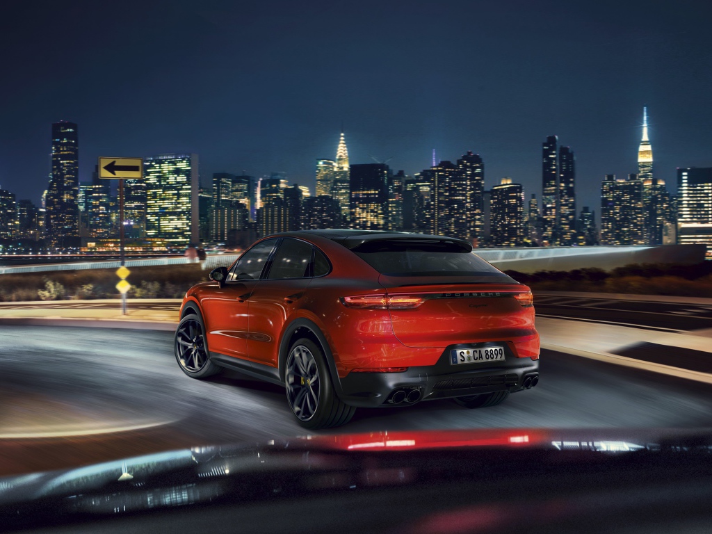 Красный внедорожник Porsche Cayenne Coupe 2019 года на фоне города