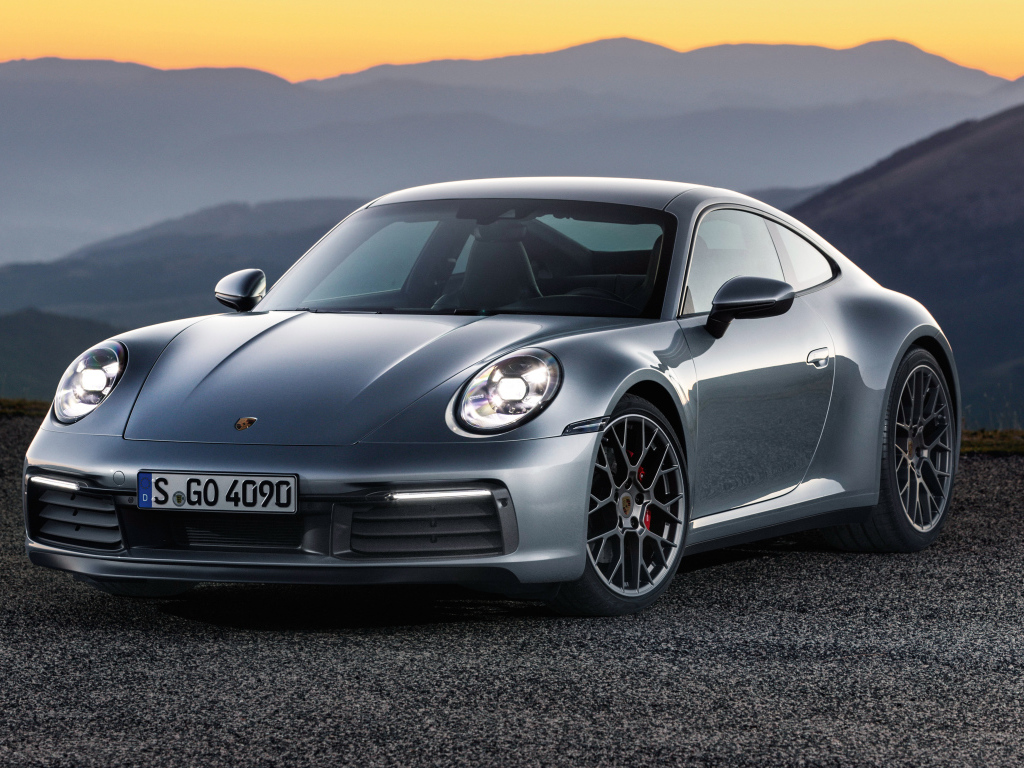 Серебристый автомобиль Porsche 911 Carrera 4S 2019 года на фоне гор 