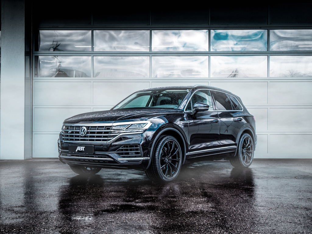 Черный автомобиль Volkswagen Touareg 2018 года у гаража