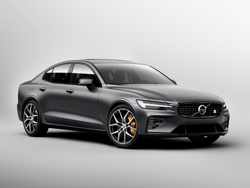 Серебристый автомобиль Volvo S60, 2018 года на сером фоне