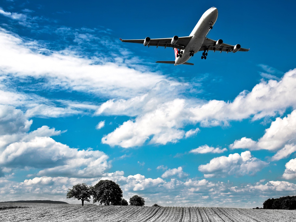 Самолет авиакомпании Swiss Airlines в небе с белыми облаками