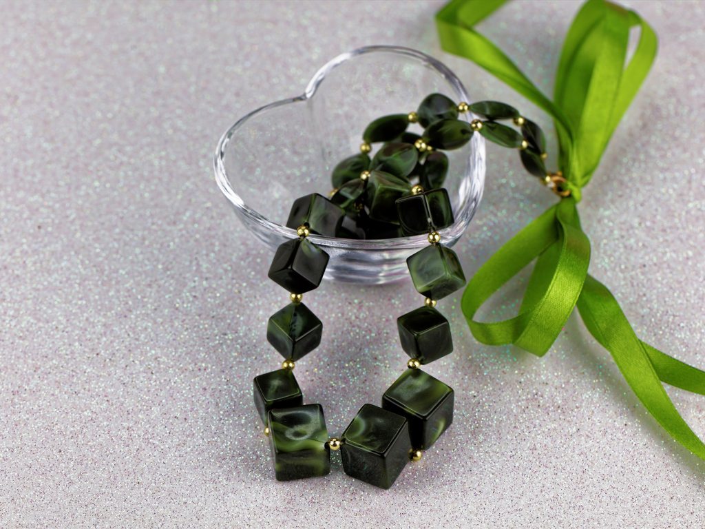 Ювелирное изделие с  бантиком в стеклянной вазочке на столе