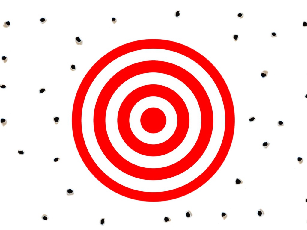 Красная мишень на белом фоне с дырками от пуль