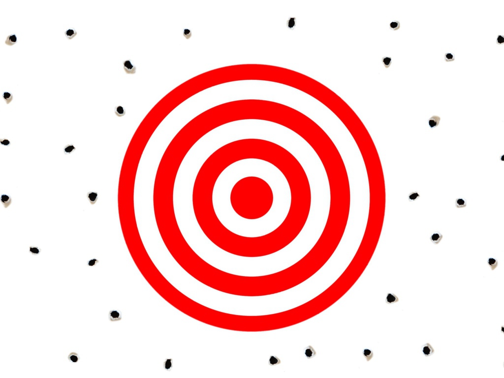 Красная мишень на белом фоне с дырками от пуль