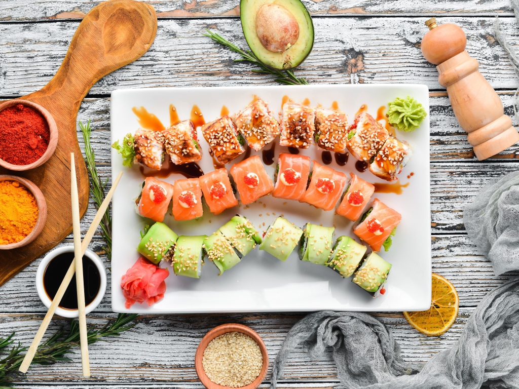 Вкусные аппетитные японские роллы на столе с соусом и специями