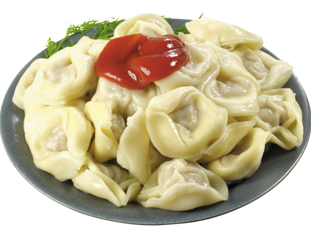 Пельмени в тарелке с кетчупом на белом фоне