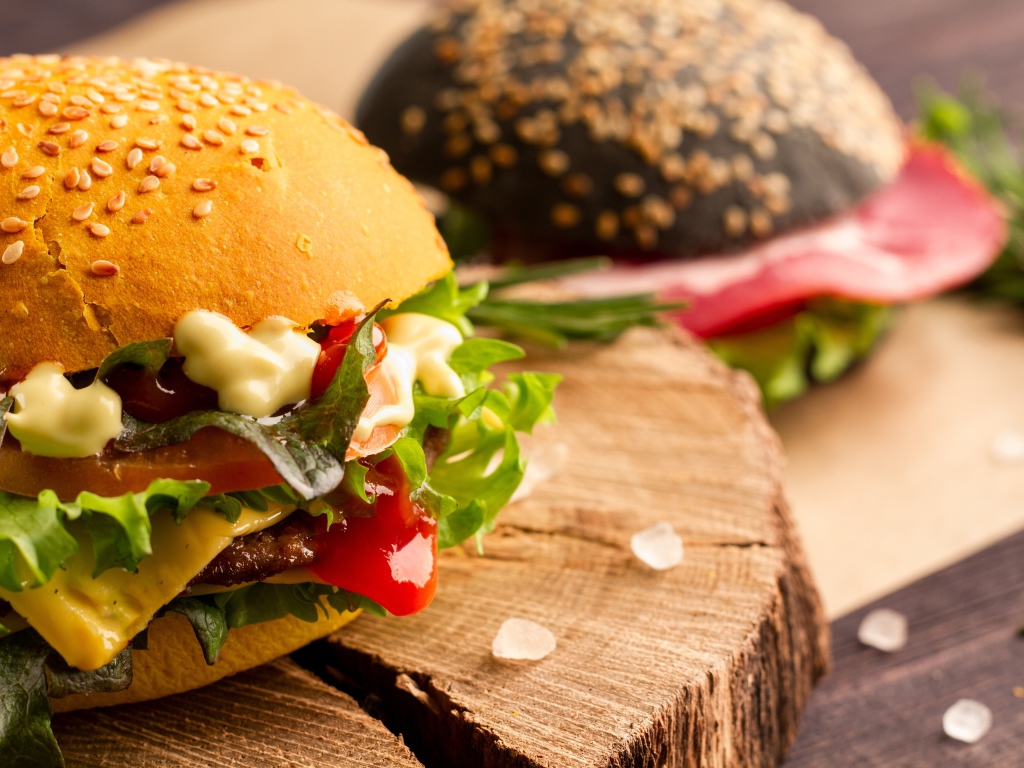 Гамбургер на деревянной доске крупным планом