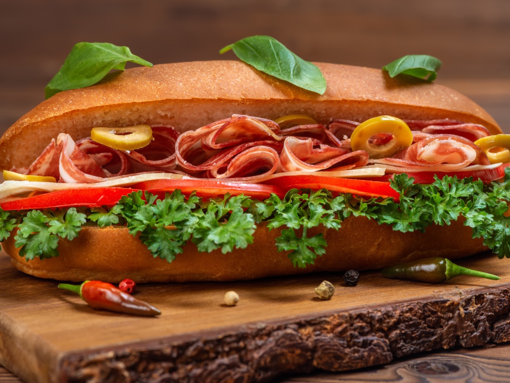 Хот дог с ветчиной, помидорами и листьями петрушки