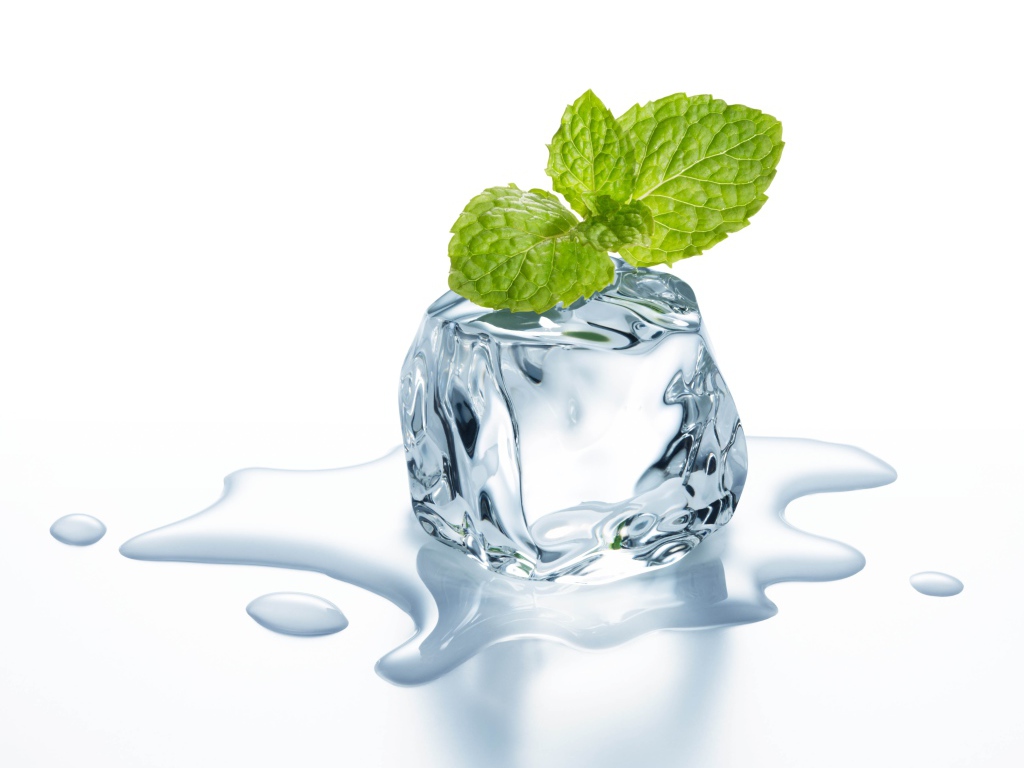 Melting ice cube with a leaf of mint on a white background