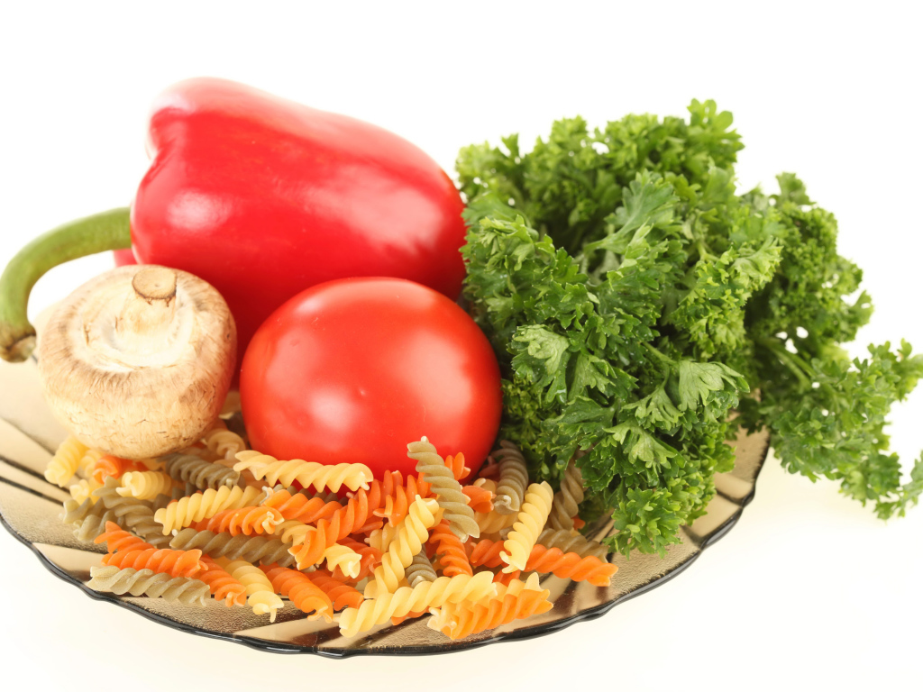 Тарелка с макаронами, красным перцем, помидором, шампиньоном и зеленью петрушки