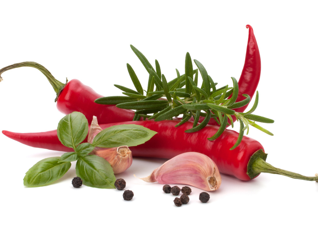 Красный перец с чесноком, базиликом, черным перцем и розмарином на белом фоне