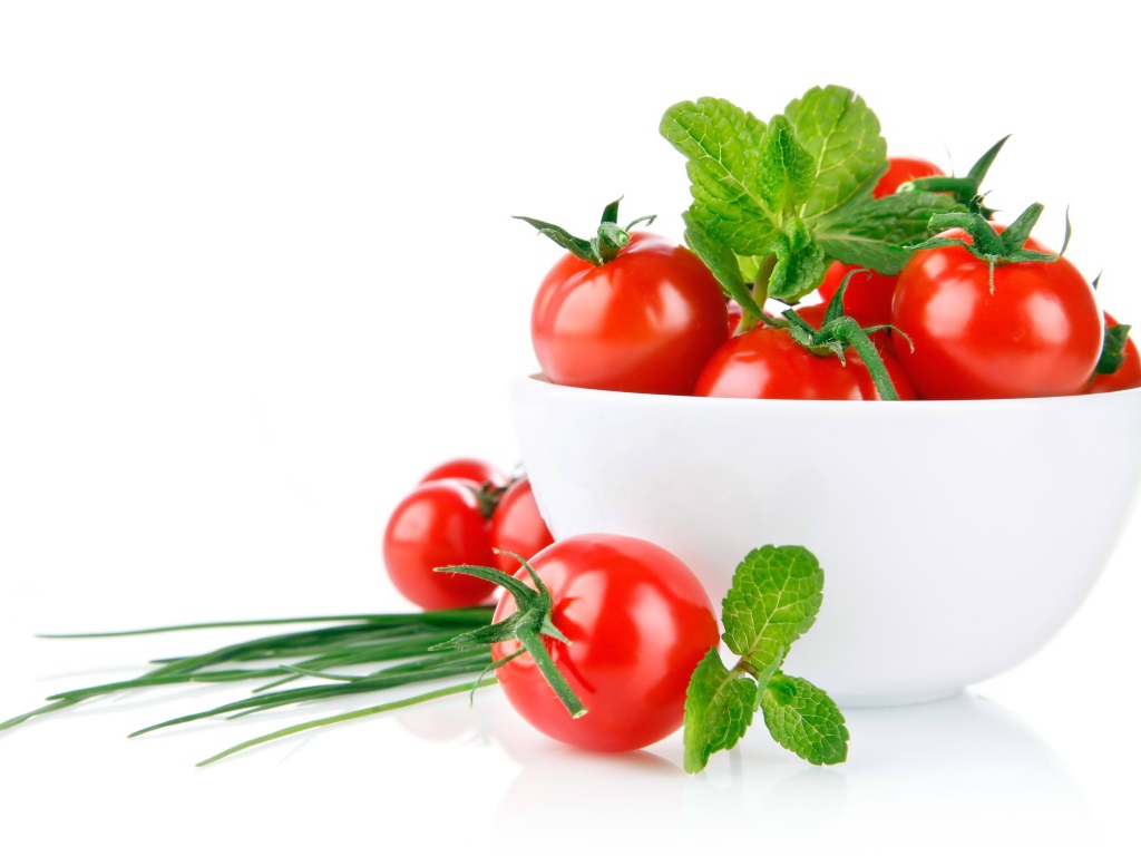 Красные помидоры с зеленым луком на белом фоне