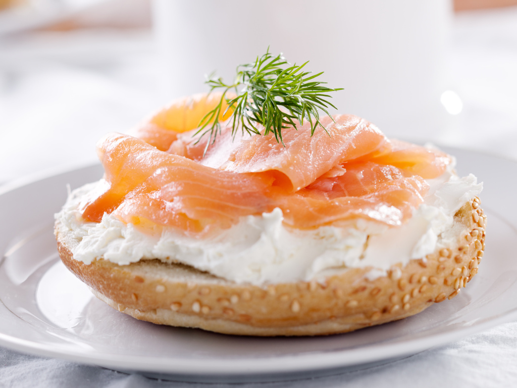 Бутерброд с сыром и красной рыбой на белой тарелке
