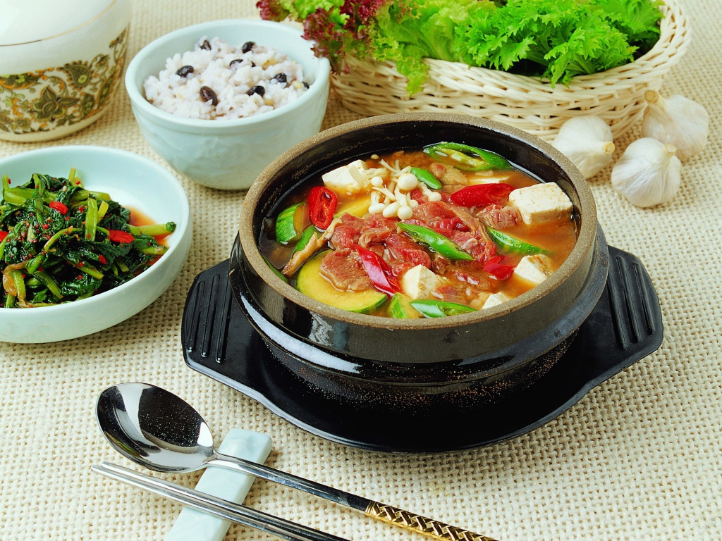 Суп с овощами и мясом на столе с закусками 