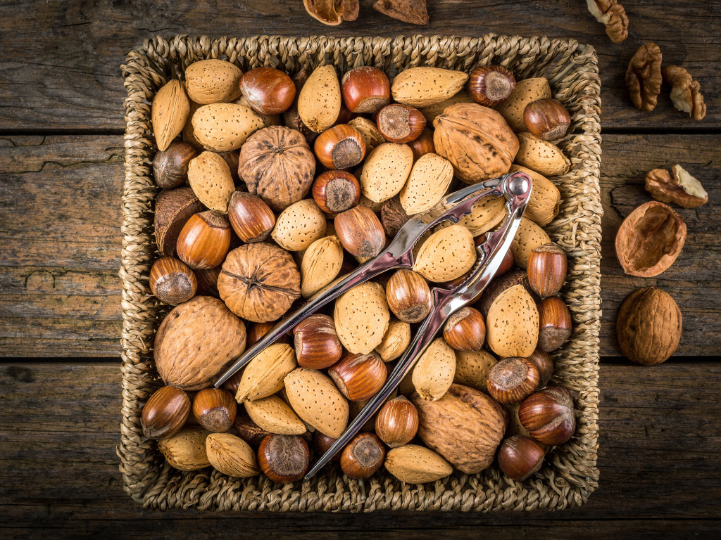 Корзина с разными орехами на столе