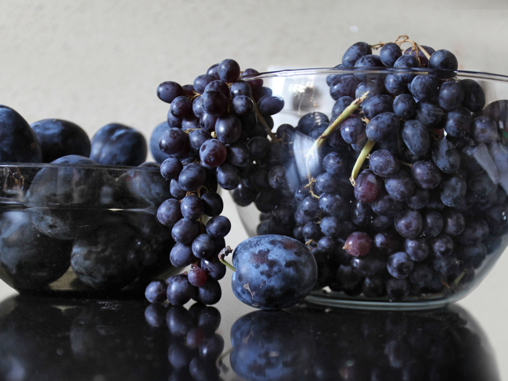 Синий виноград с синими сливами на столе