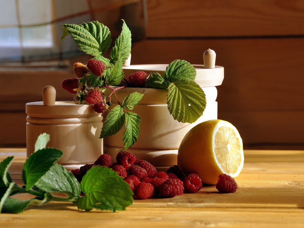 Посуда на столе с малиной и лимоном