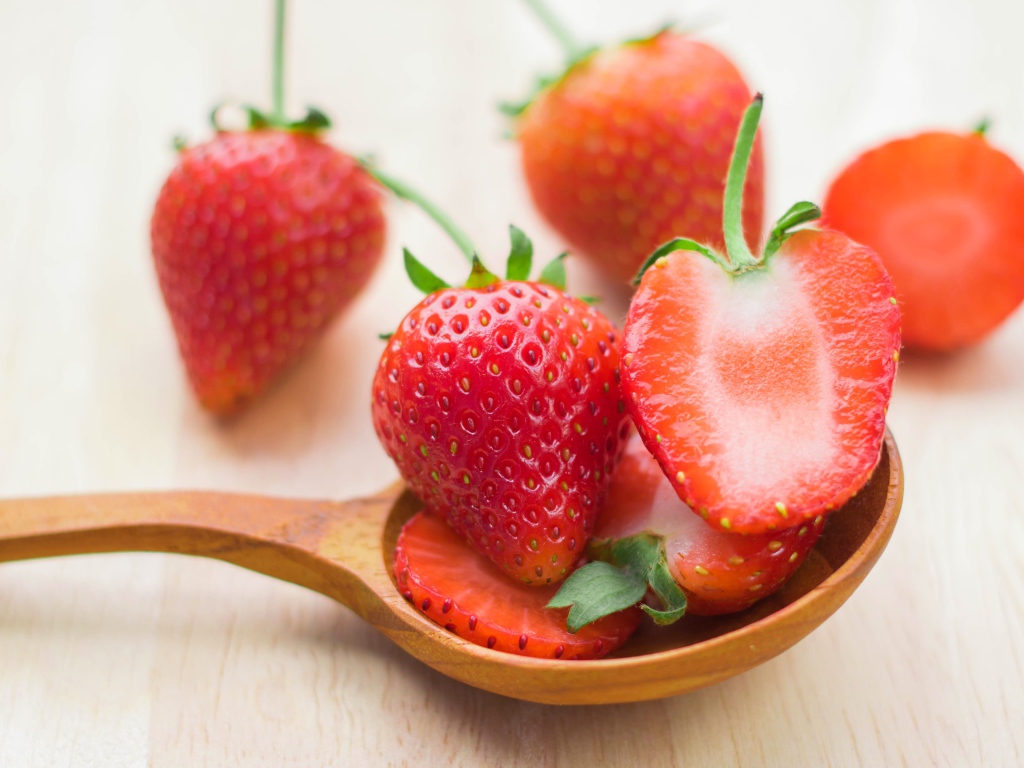 Свежая красная клубника лежит на деревянной ложке