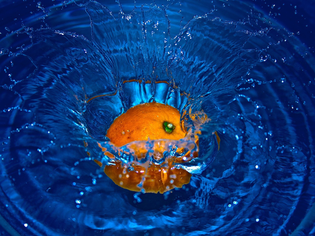 Оранжевый апельсин упал в воду 