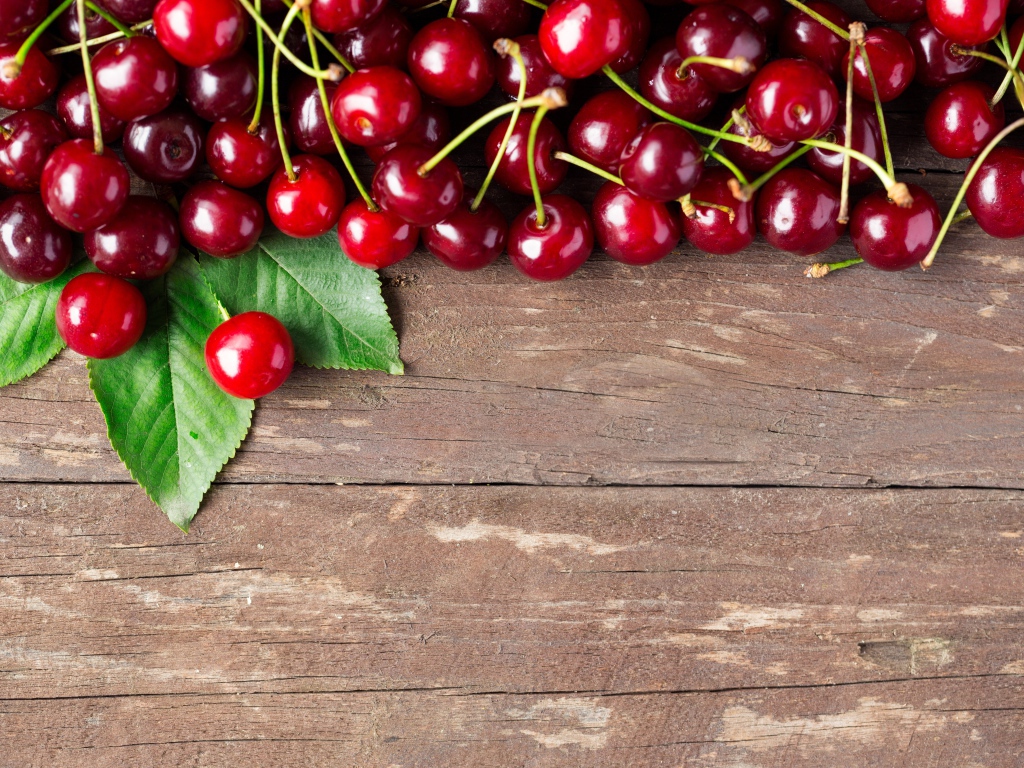 Красные спелые вишни на деревянном столе