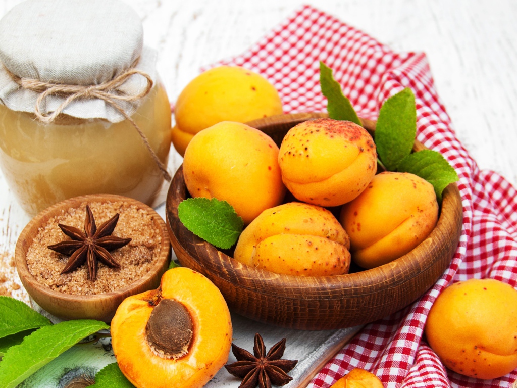 Спелые абрикосы на столе с бадьяном, коричневым сахаром и джемом