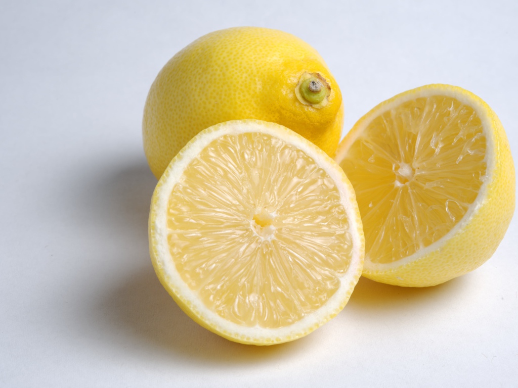 Желтые кислые лимоны на сером фоне