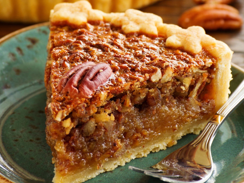 Кусок пирога с орехами на тарелке с вилкой