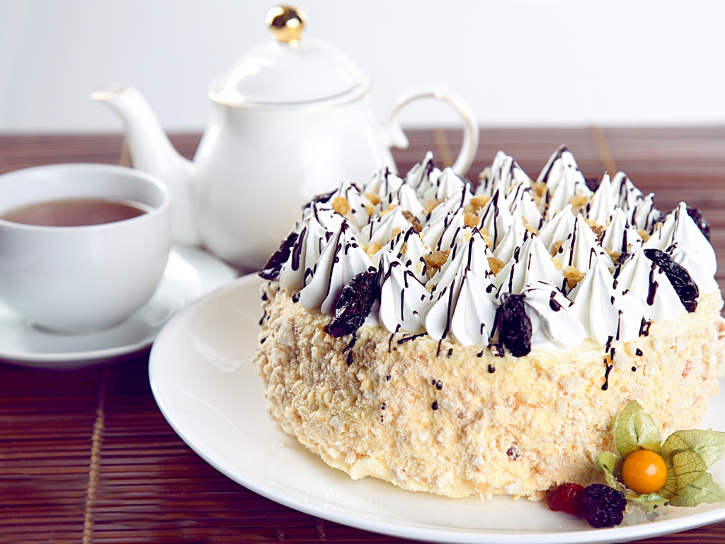 Красивый праздничный торт с безе на столе с чаем