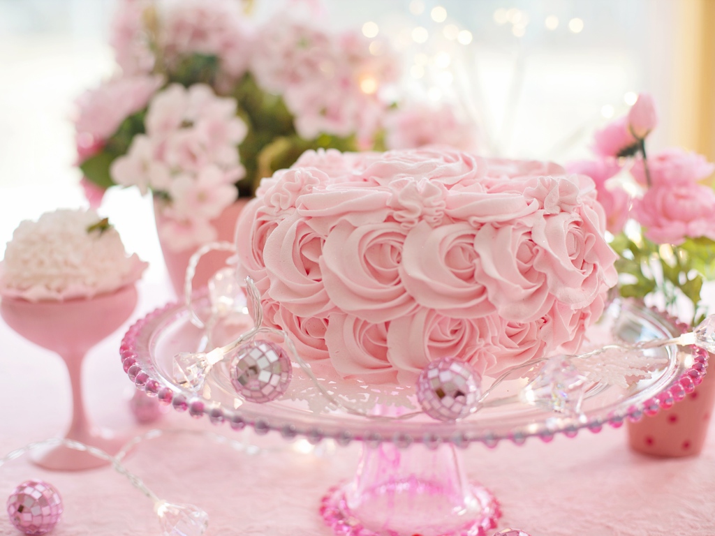 Красивый розовый торт на столе с цветами