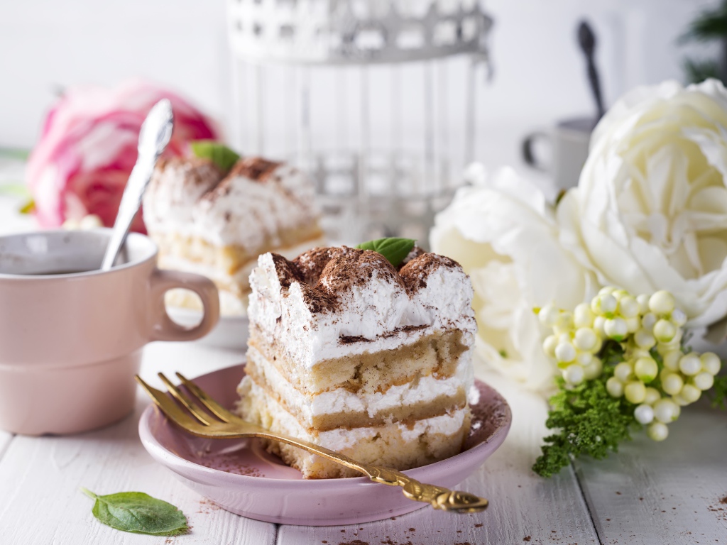 Пирожное на столе с кофе и цветами 