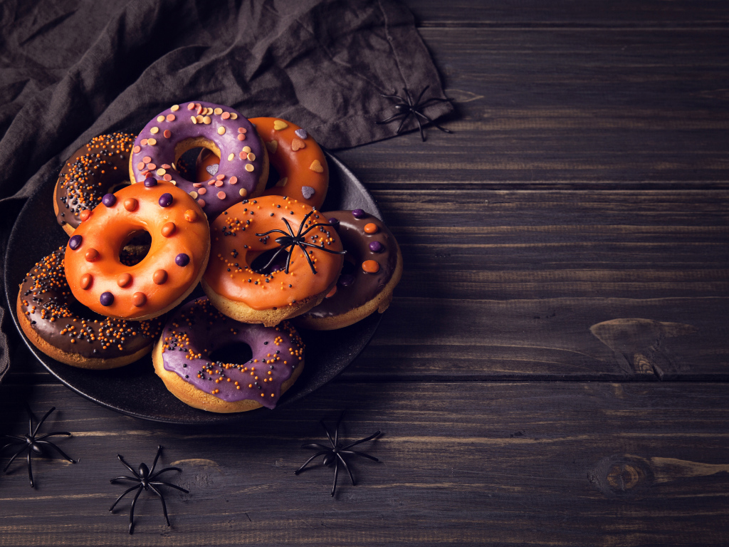 Пончики с глазурью на столе угощение на Хэллоуин 