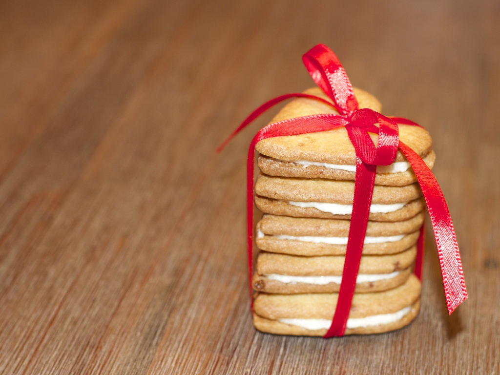 Печенье в форме сердца перевязано красной лентой 