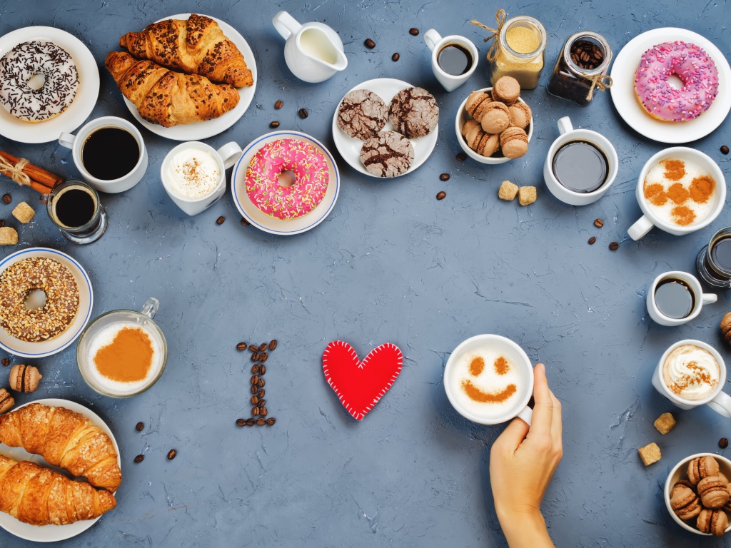 Много сладкой выпечки с кофе на сером фоне