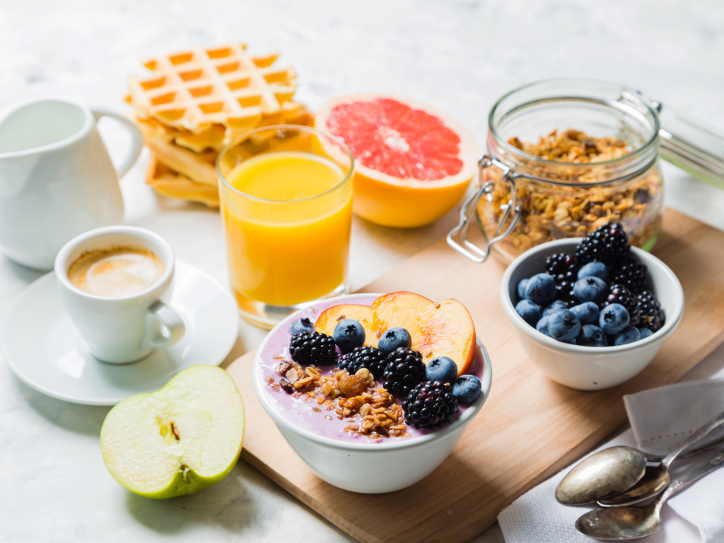 Мюсли с ягодами на столе с соком и кофе