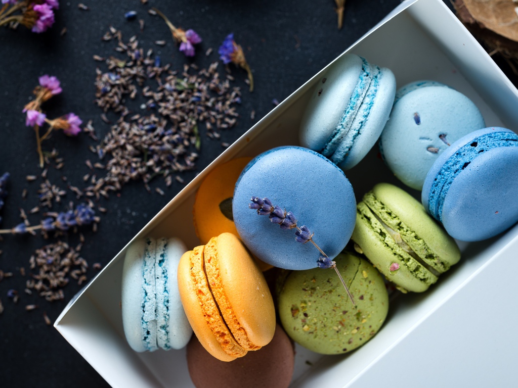 Разноцветный десерт макарон в коробке на столе с лавандой