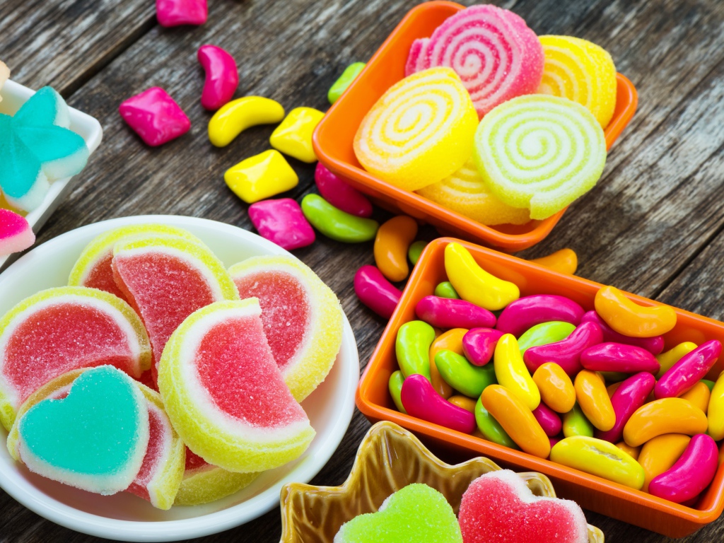 Разноцветный мармелад с конфетами на деревянном столе