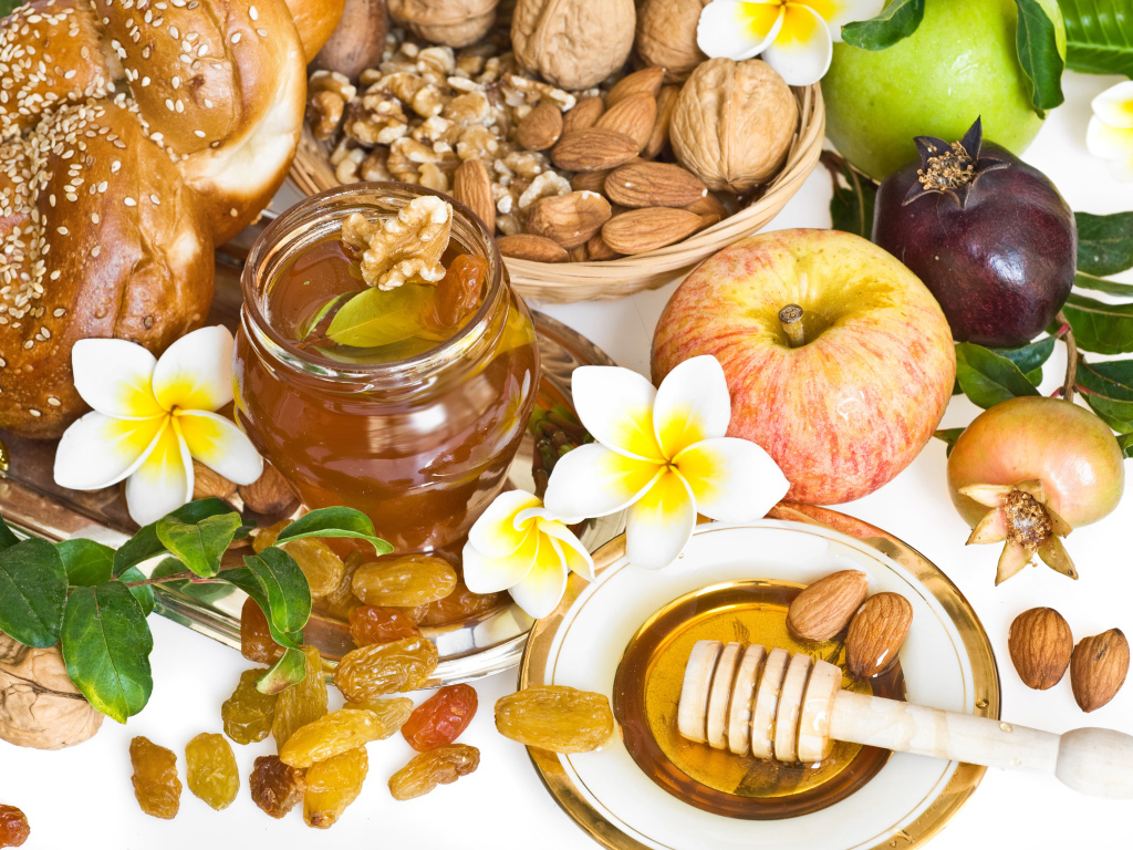 Орехи, мед, яблоки и выпечка с изюмом на столе к празднику