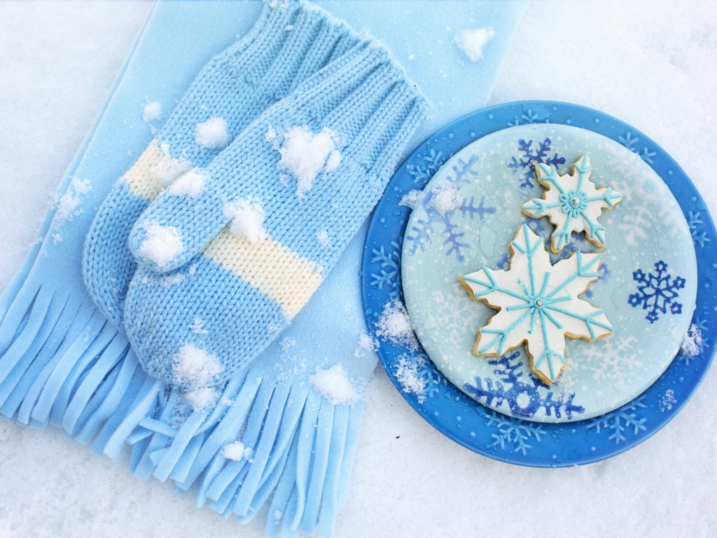 Печенье снежинки на снегу с шарфом и рукавицами