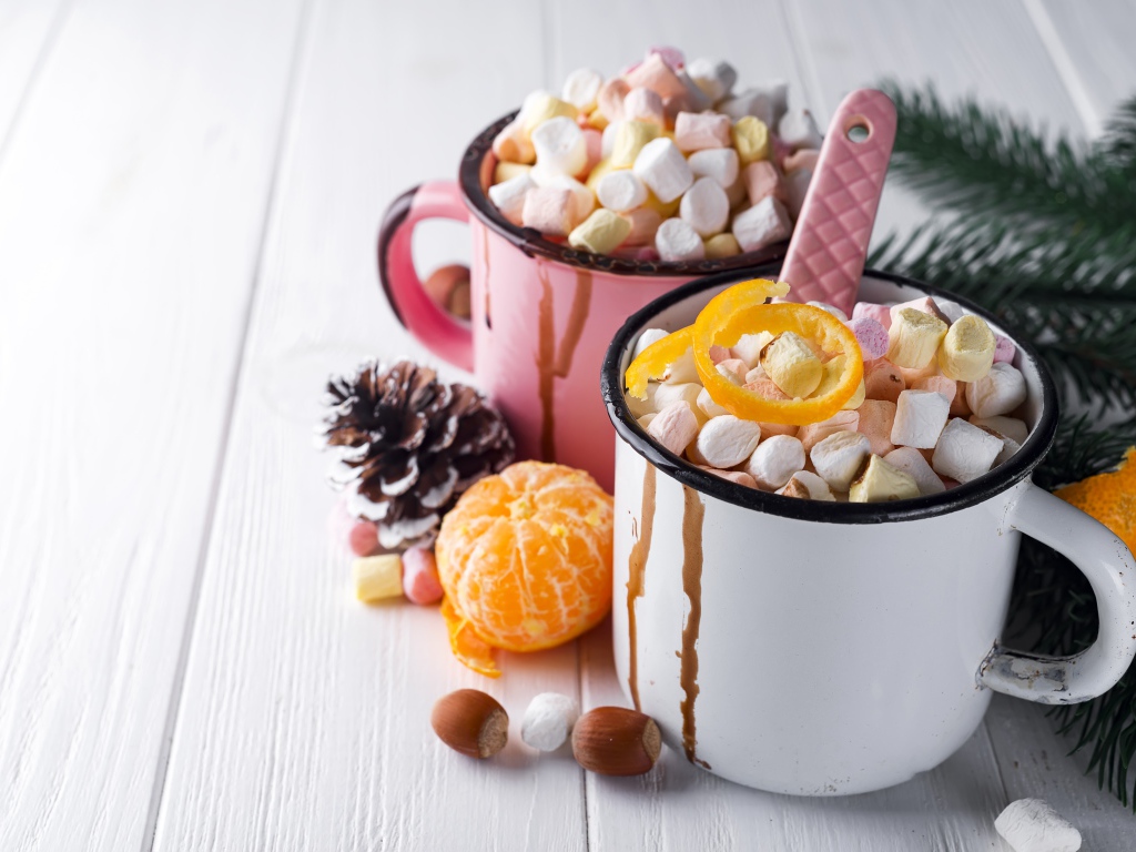 Две железные кружки с маршмеллоу на столе 